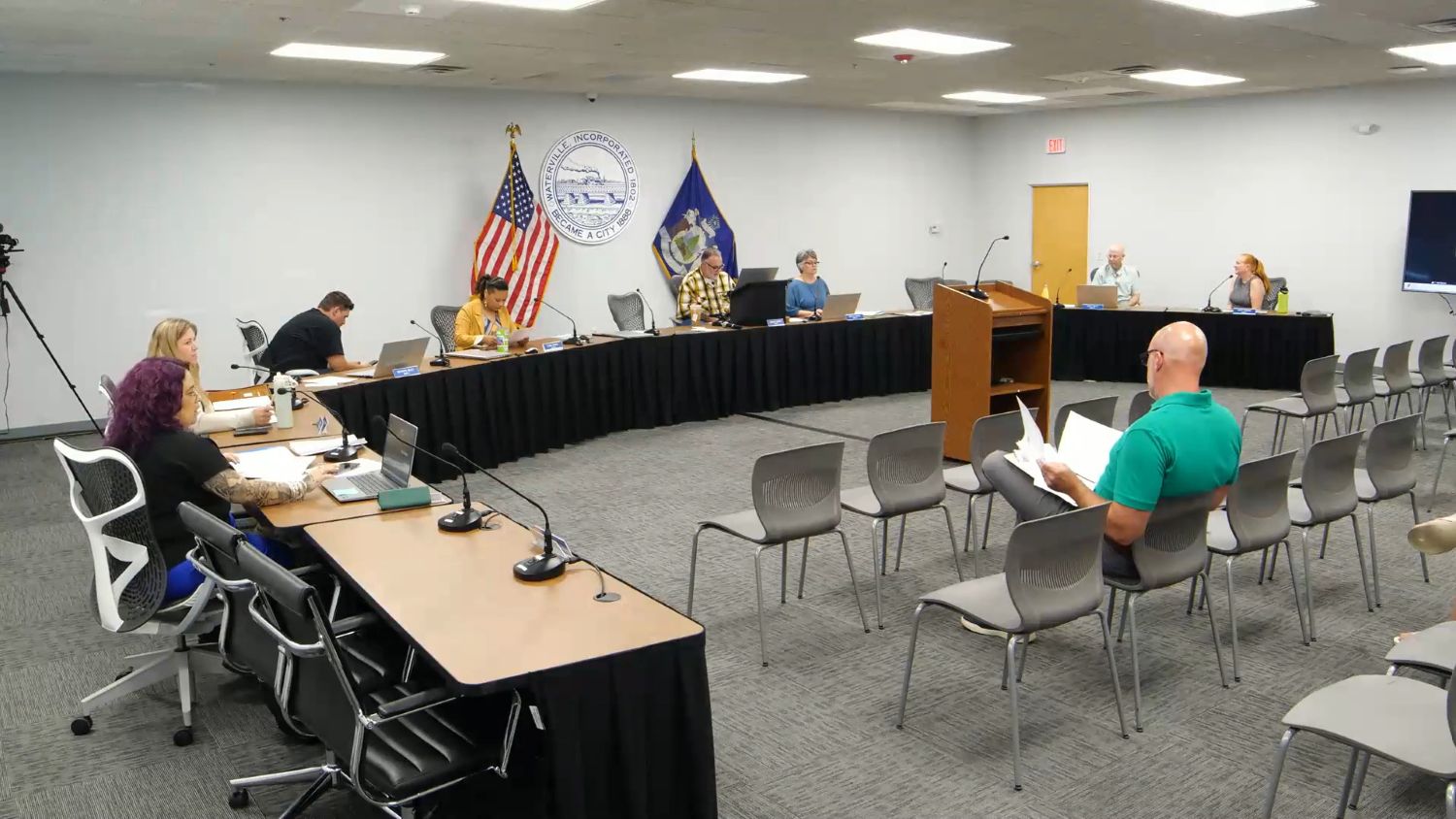 city council members sit around a long meeting table.