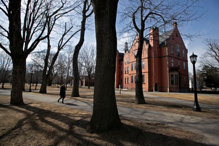 person walking past a building on the bowdoin campus