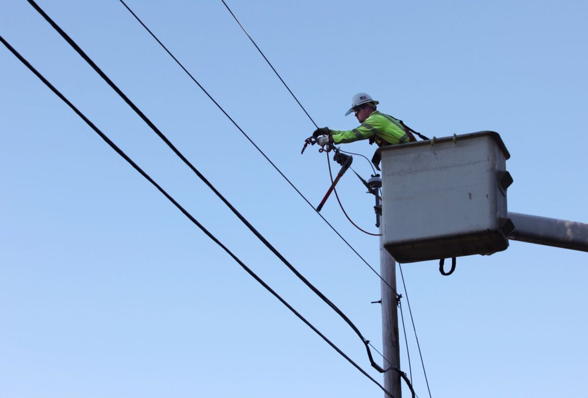 a utility worker replaces a power line