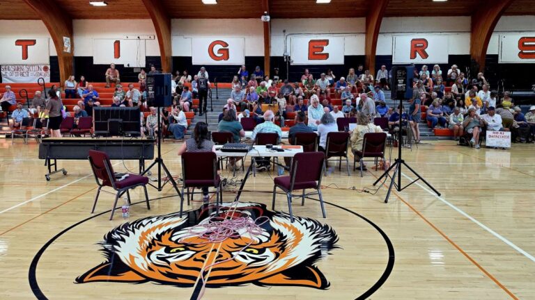 residents gather in a gym for a public hearing.