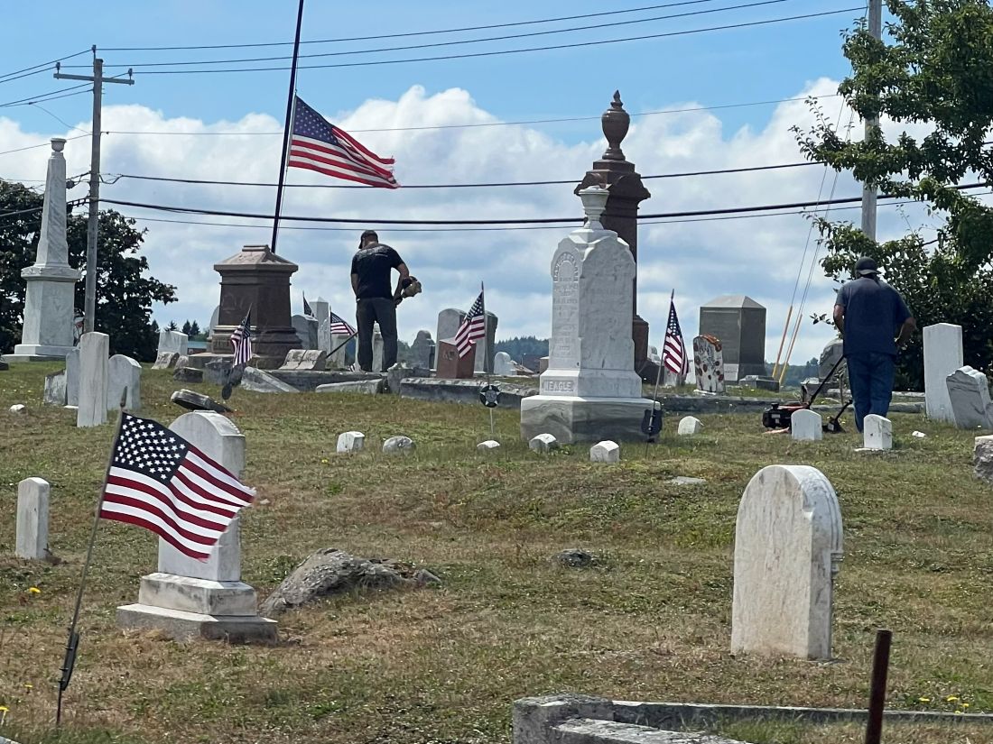 a maintenance worker at the cemetery weedwacking
