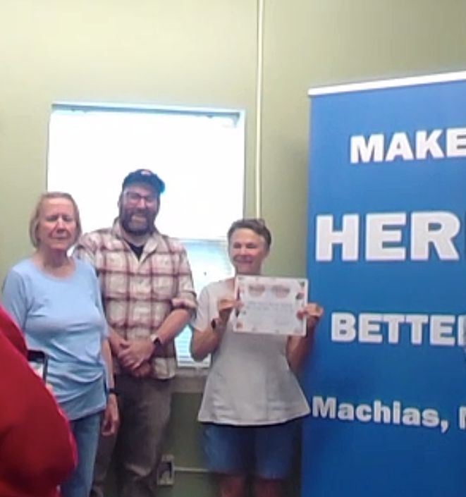individuals pose with the award certificate