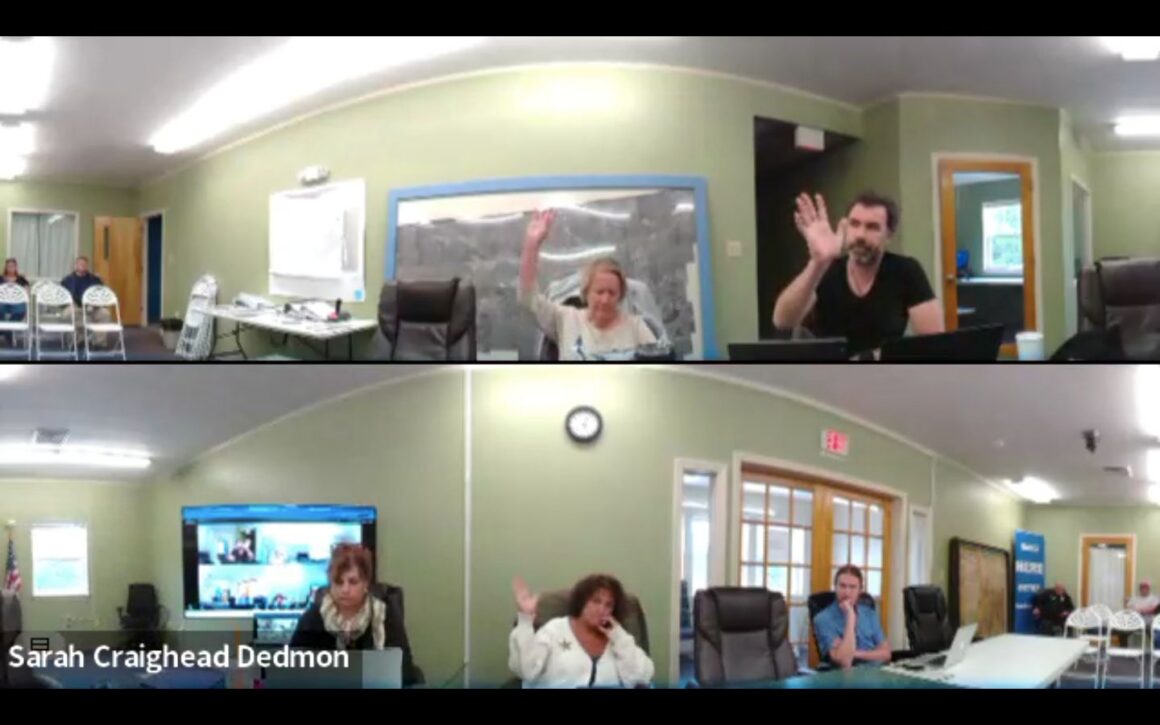 members of the machias select board cast votes during a meeting.