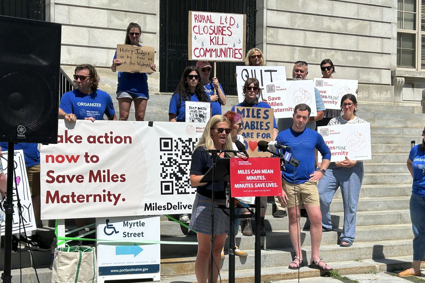 Hannah Pingree speaks during the demonstration while standing at a podium.