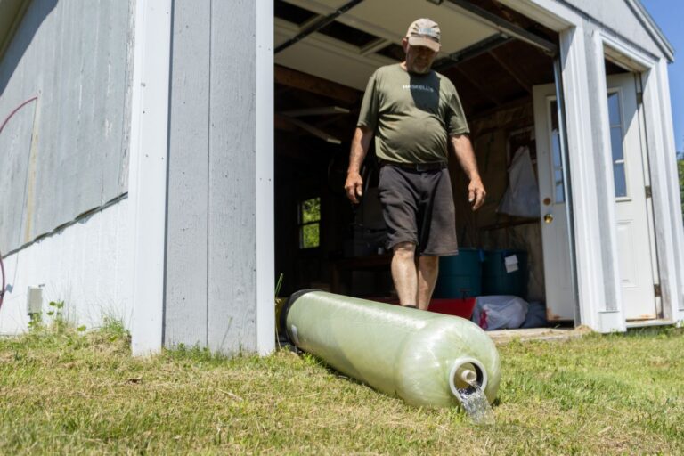 water from a filter spills into grass