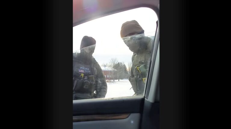 two ice agents seen through a car window