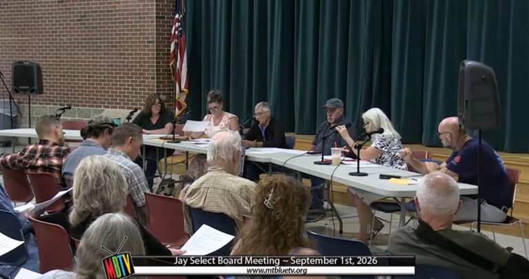 members of the select board sit at a table