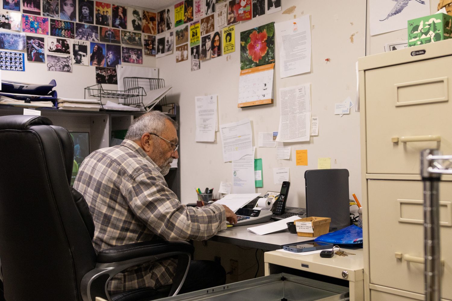 a man using a calculator while sitting at a desk