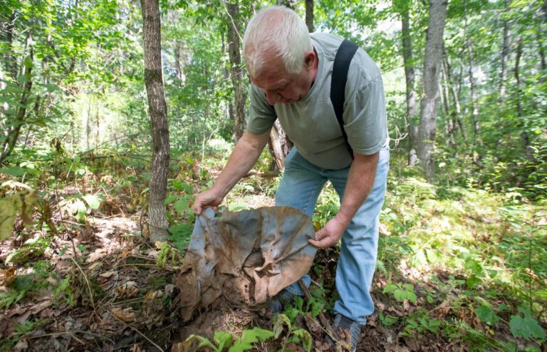 Rod Pease holding tannery hides in the forest.