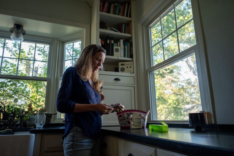 Tracey Collins examining an item in her hands.