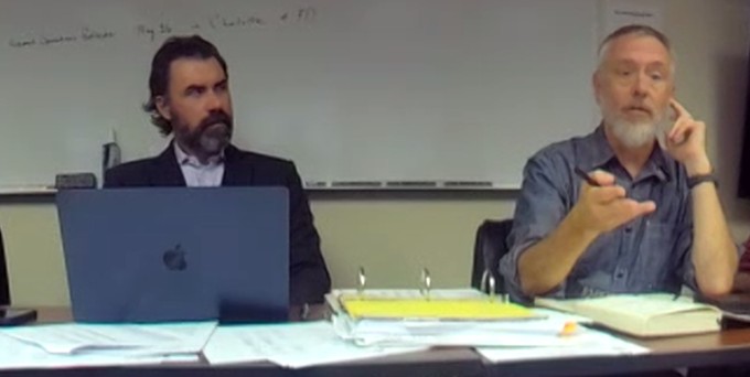 two men sit at a table during the meeting