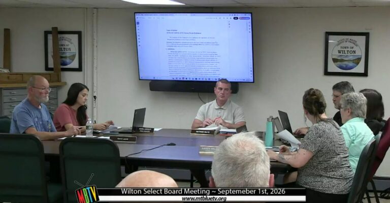 board members sit around a table during a meeting.