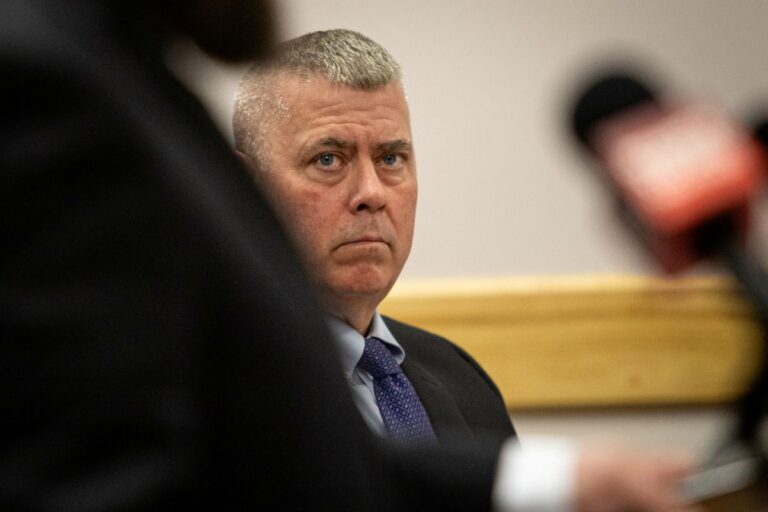 Christopher Wainwright looks at a speaker during a hearing.