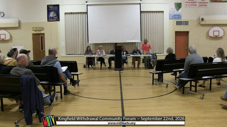 a committee member stands while addressing the crowd