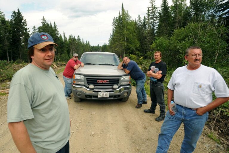 men standing near a truck looking at a scene not captured in the photo